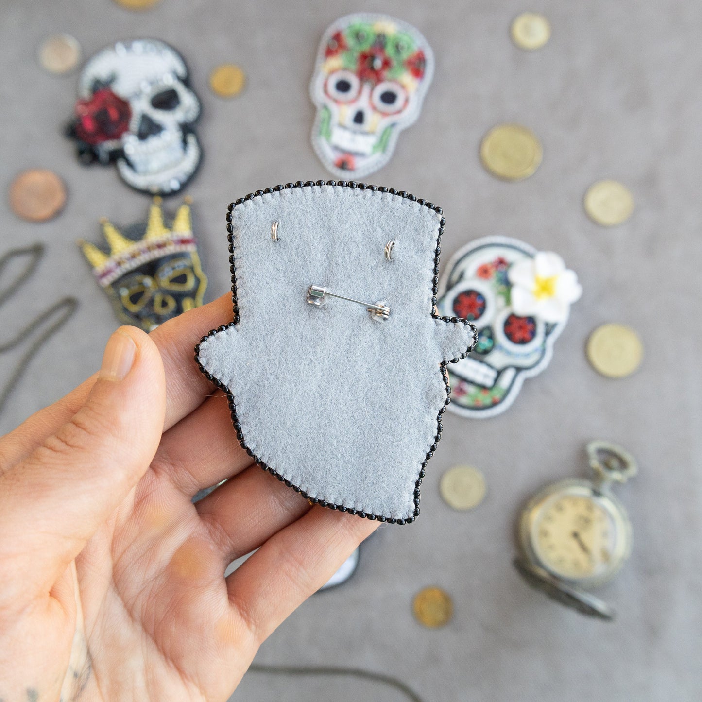 a person holding a piece of felt with a picture of a skull on it