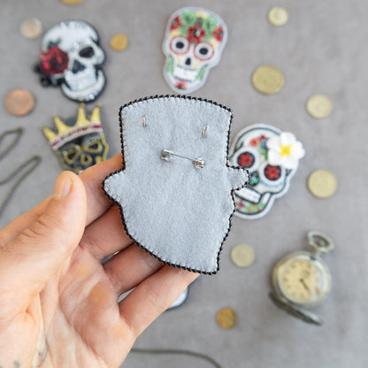 a person holding a piece of felt with a picture of a skull on it