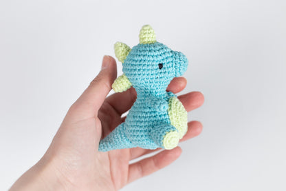 a hand holding a small crocheted stuffed animal