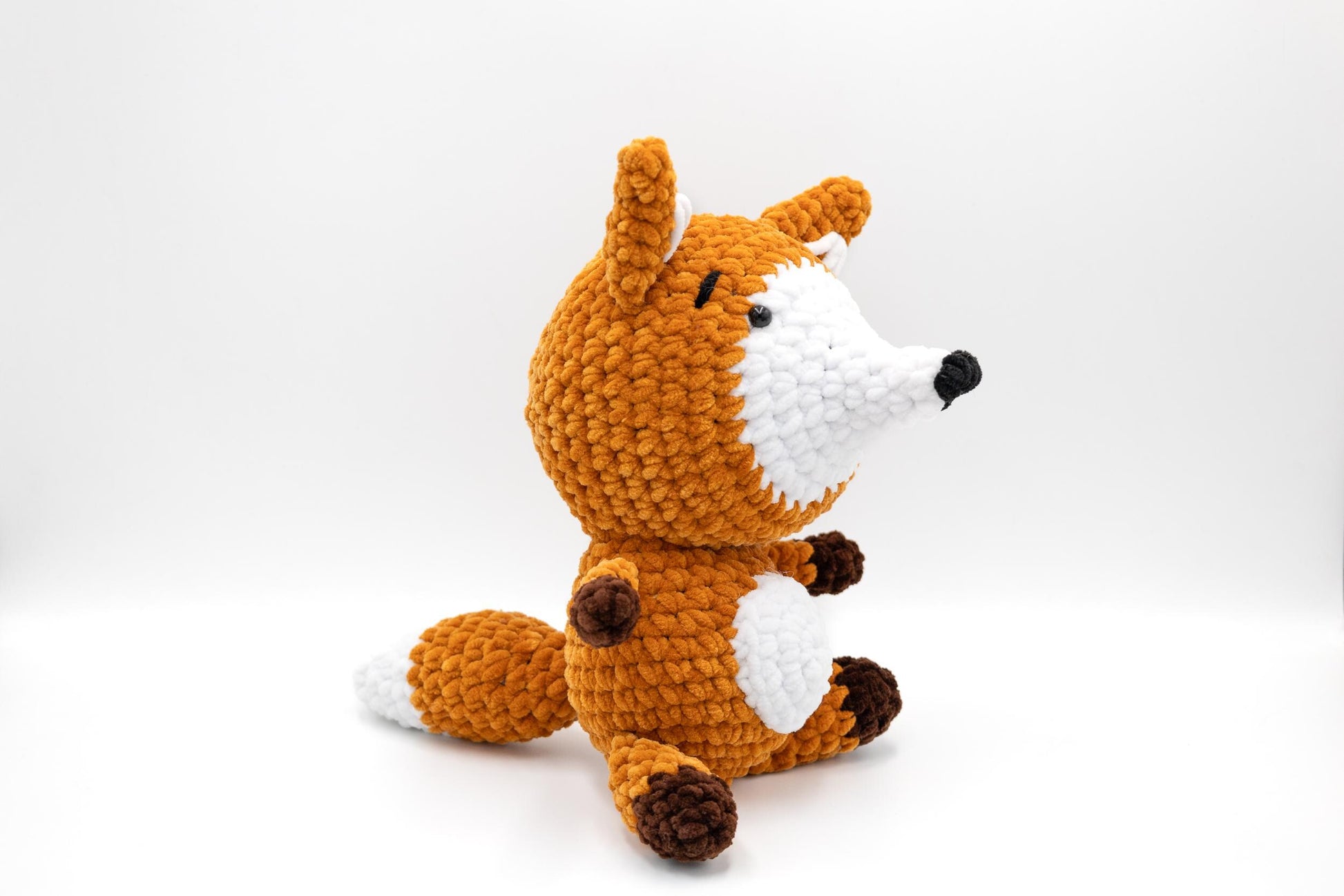 a crocheted stuffed animal sitting on a white surface