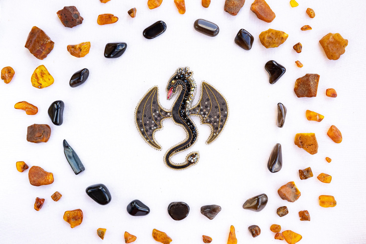 a dragon brooch sitting on top of a white surface