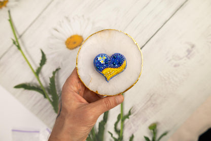 a hand holding a decorated cookie with a heart on it