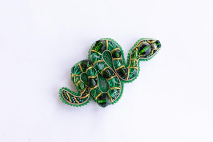 a green brooch with a snake design on it