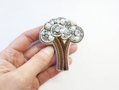 a person holding a brooch in their hand