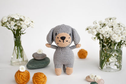 a crocheted stuffed animal next to a vase of flowers