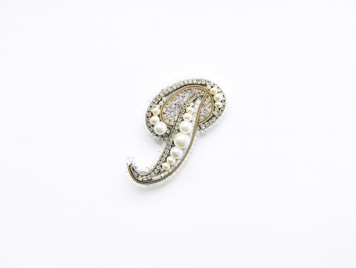 A decorative brooch with a pendant made of pearls and diamonds.