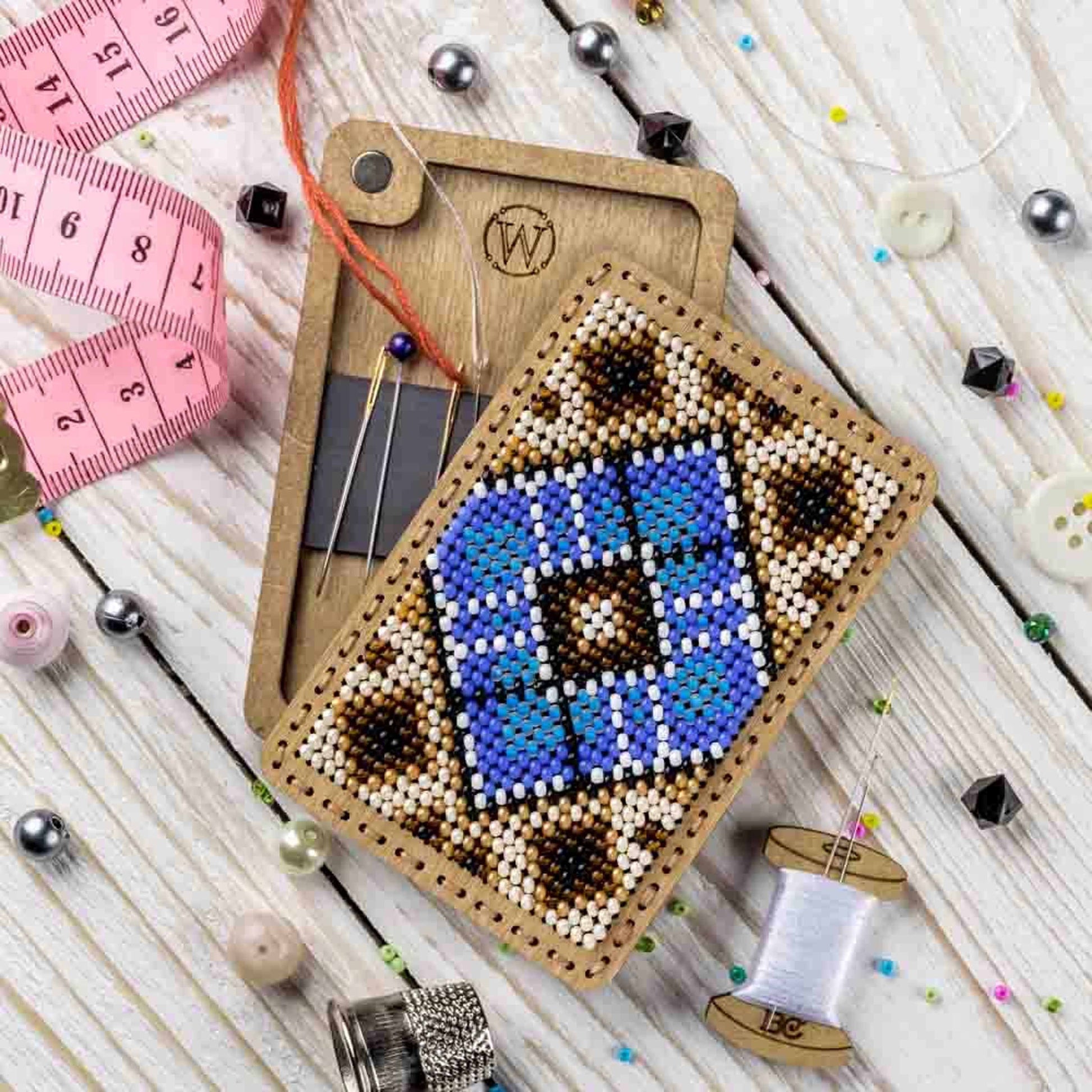 a cross stitch ornament next to a sewing needle