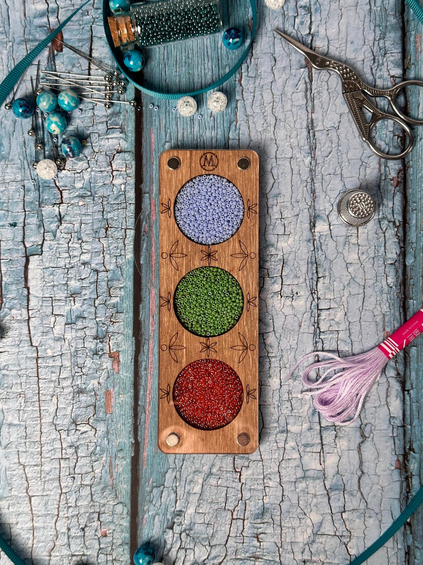 a wooden board with beads and a pair of scissors