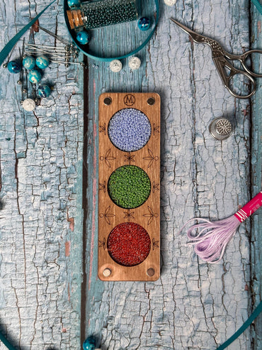 a wooden board with beads and a pair of scissors