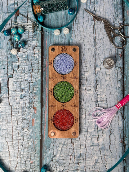 a wooden board with beads and a pair of scissors