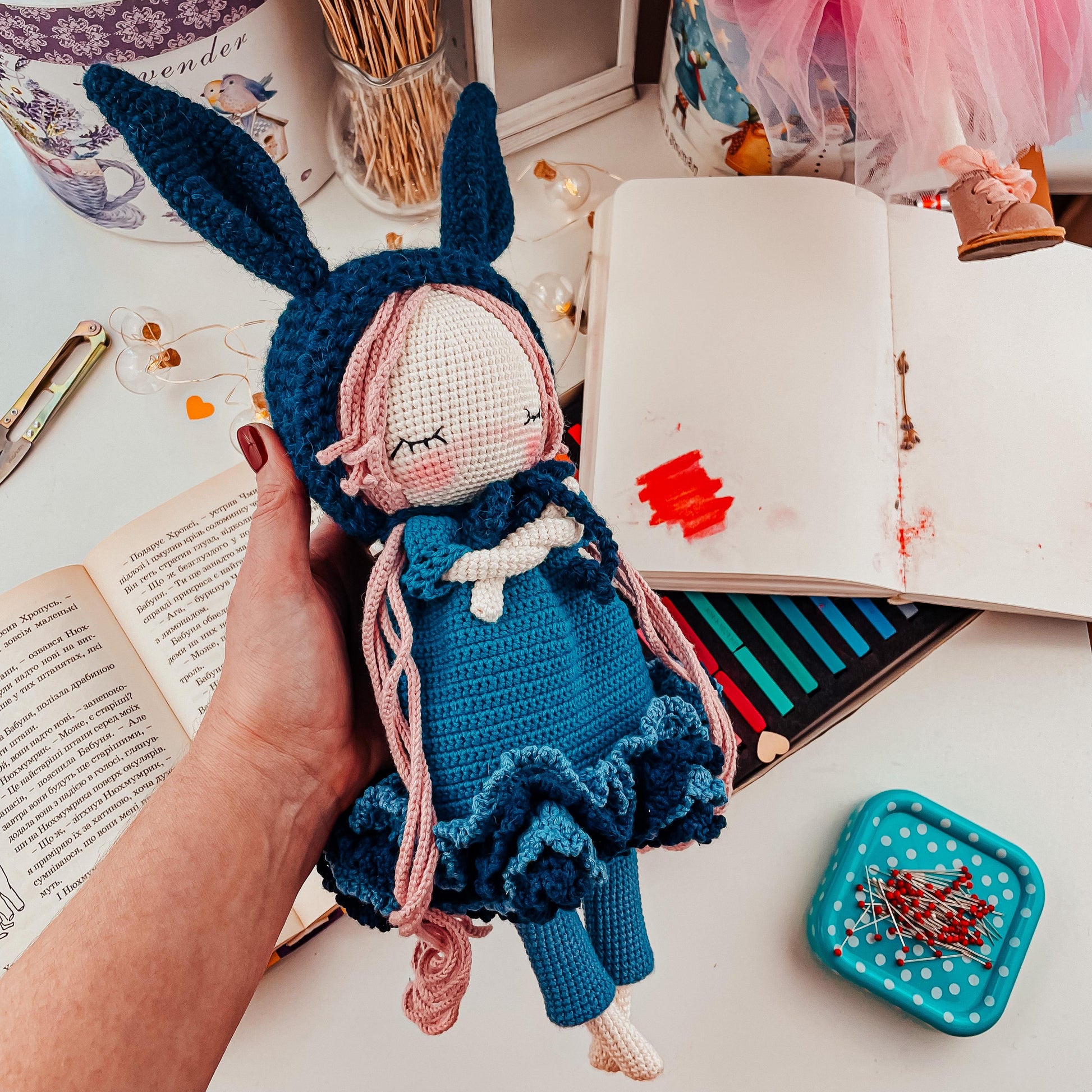 a person is holding a doll in front of a book
