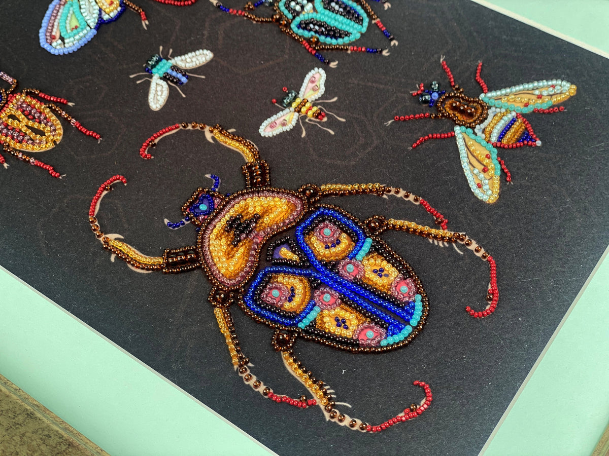a close-up view of a detailed beaded artwork depicting a large, colorful beetle with intricate patterns and designs.