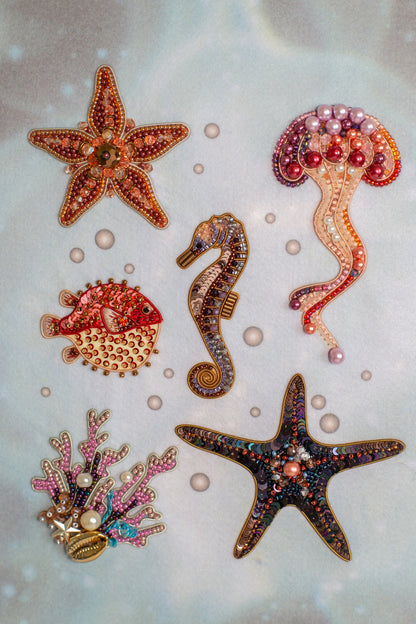 a collection of six decorative sea-themed items, including a starfish, a pufferfish, a jellyfish, a seahorse, a pearl, and a starfish, all adorned with intricate beading and embellishments.