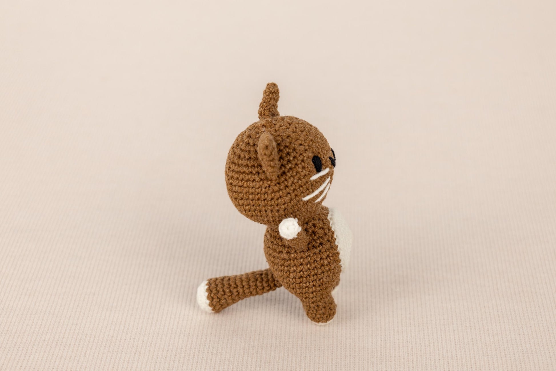 a small crocheted cat sitting on its hind legs