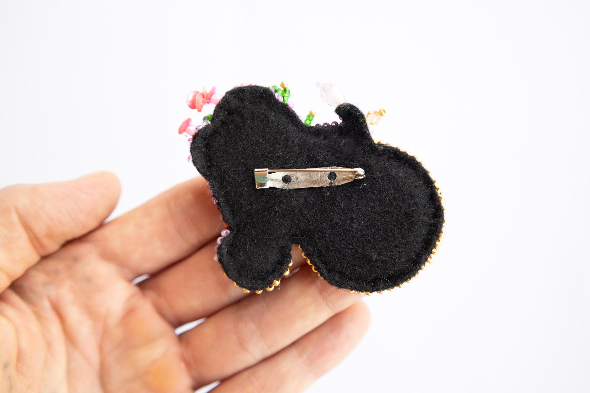 a small black brooch with a pair of scissors in it