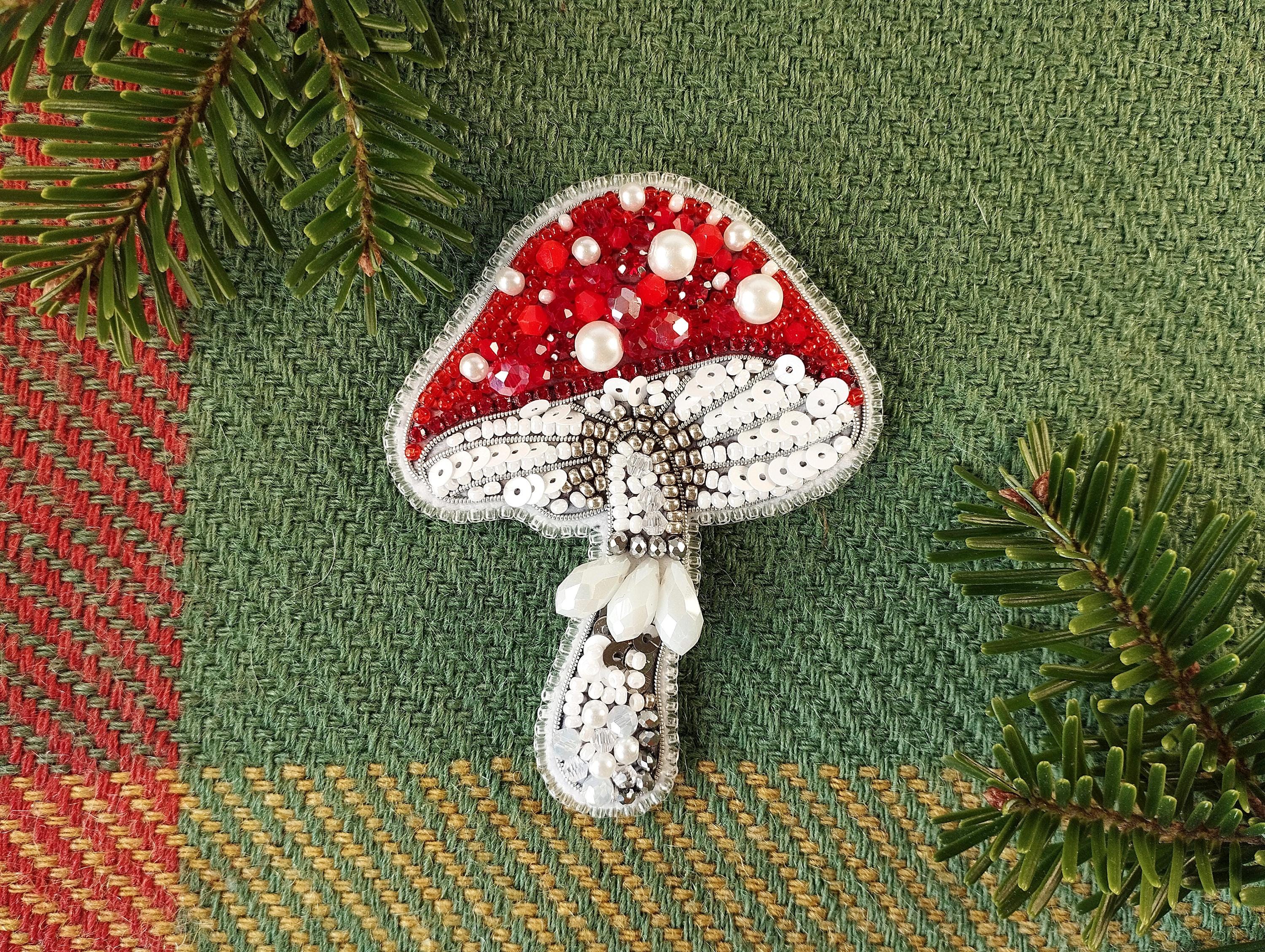 a brooch with a red and white mushroom on it