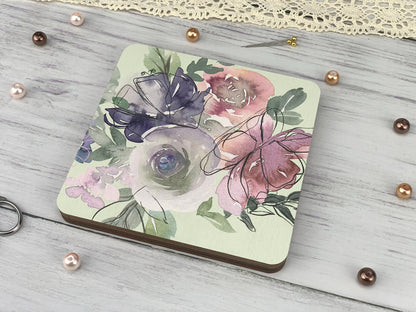 a coaster with a floral design on it next to a pair of scissors