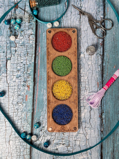 a wooden tray with beads and a pair of scissors