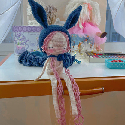 a doll is sitting on a table next to a doll