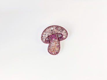 a brooch with a pink and white design on it