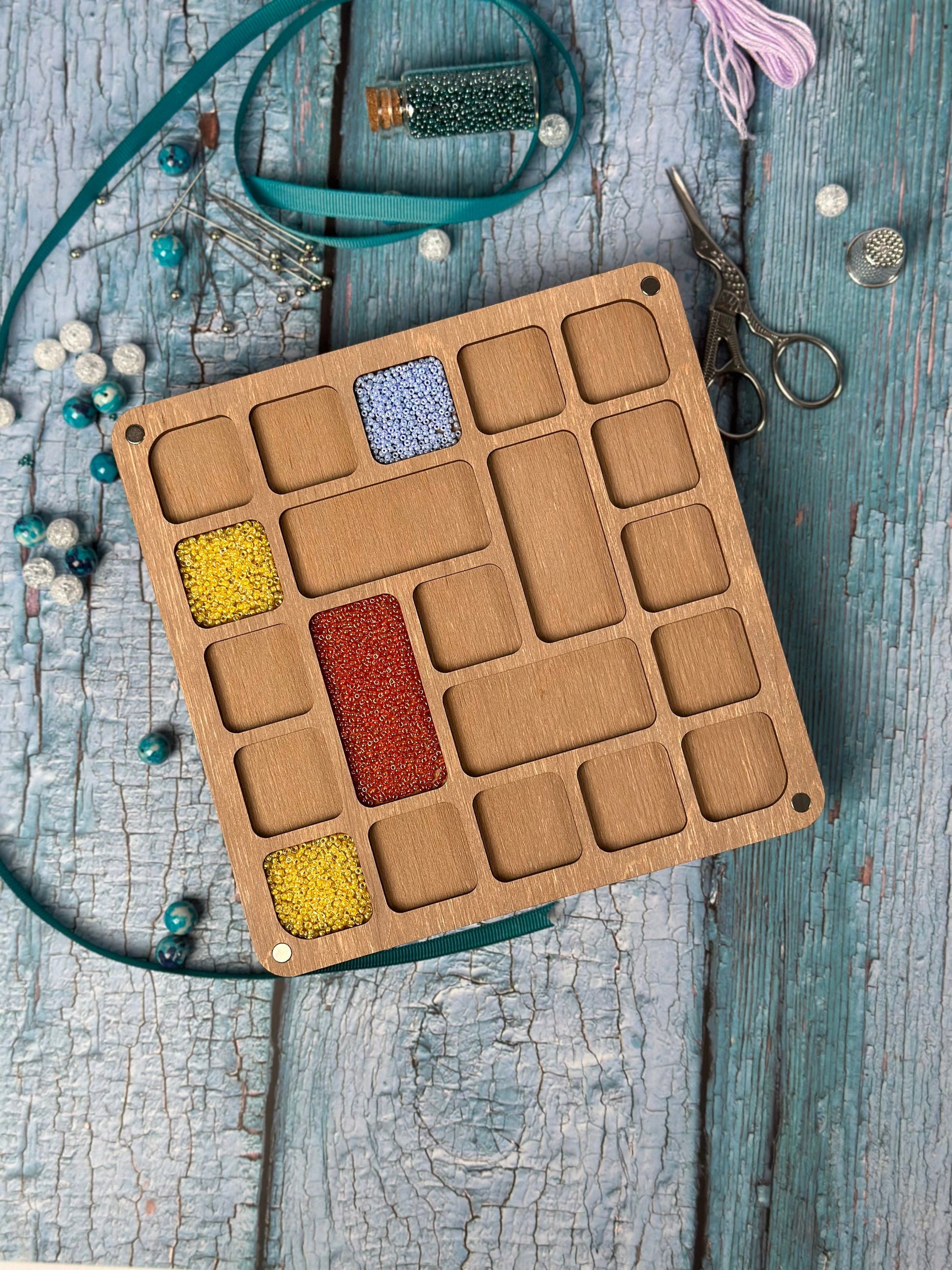 a box of beads sits on a wooden table