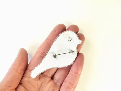 a person holding a small white clock in their hand