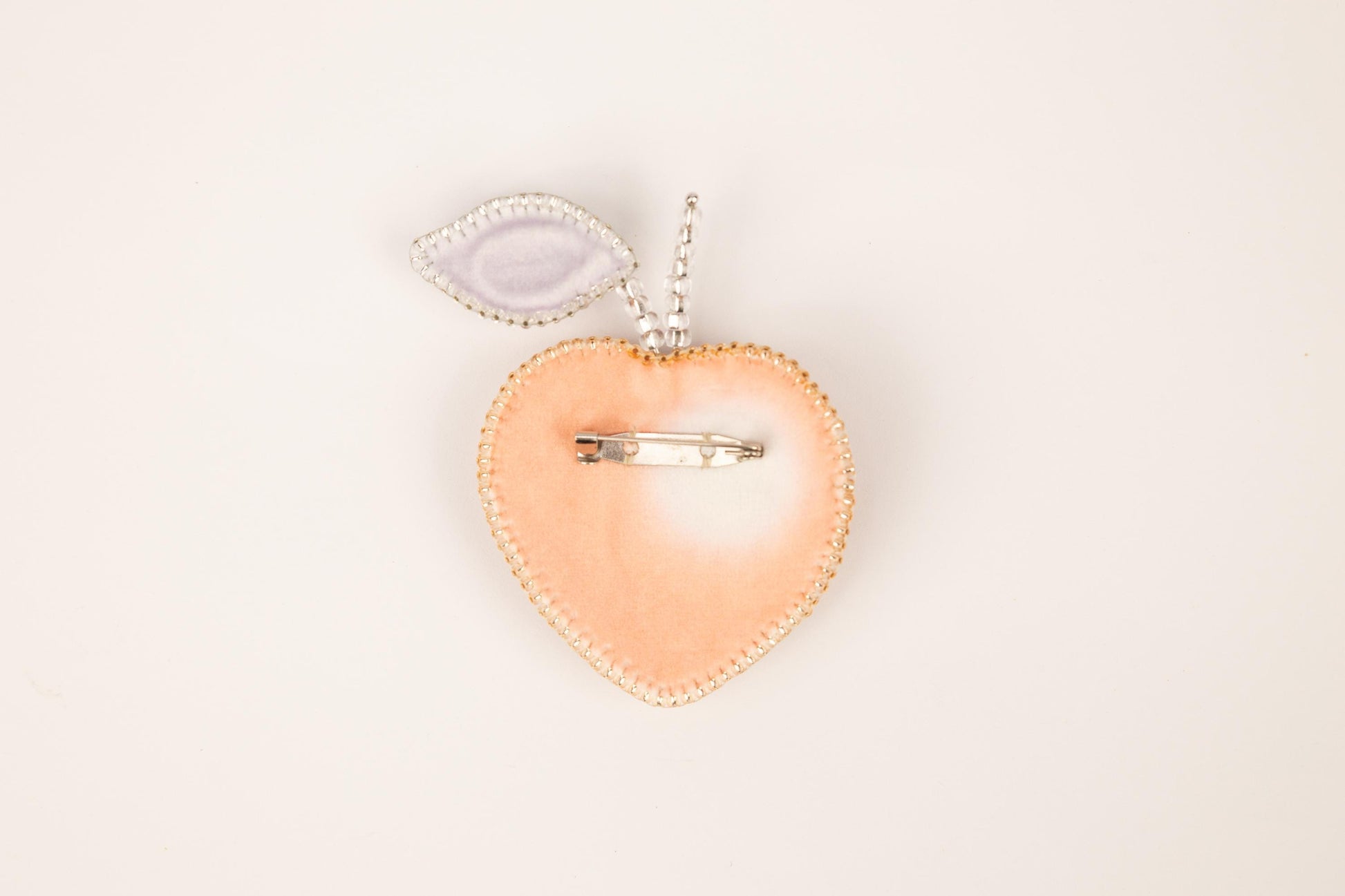 a heart shaped brooch with a pair of scissors in it