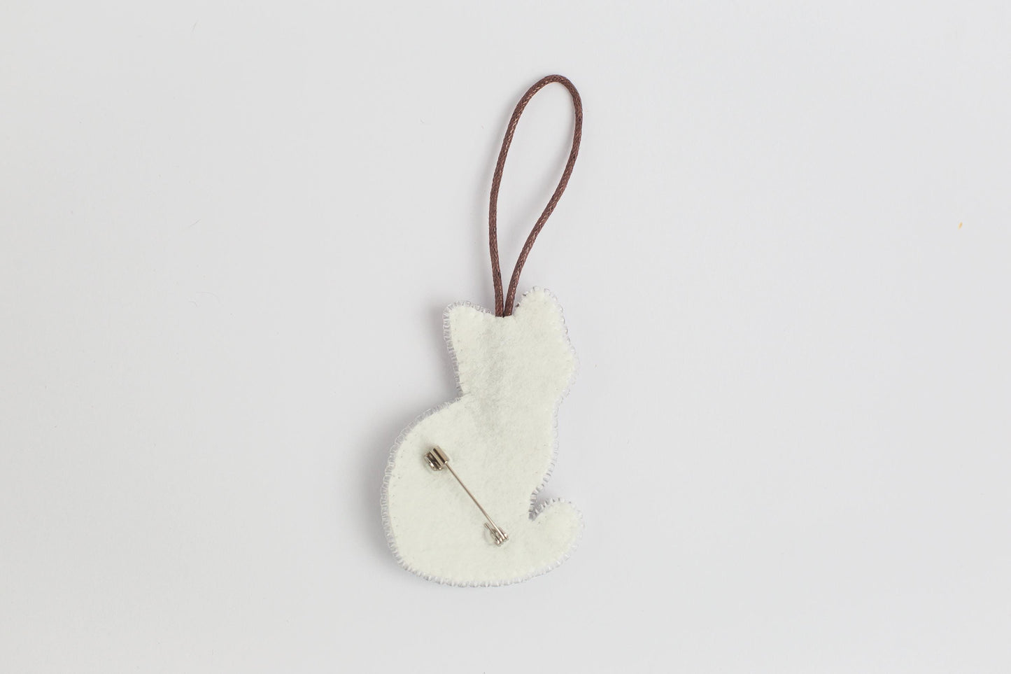 a white ornament hanging from a brown cord