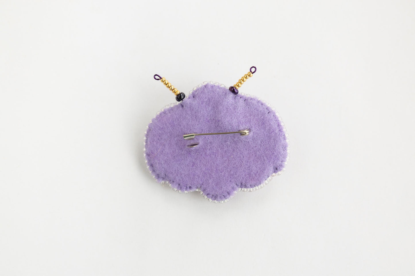 a purple pin cushion sitting on top of a white table