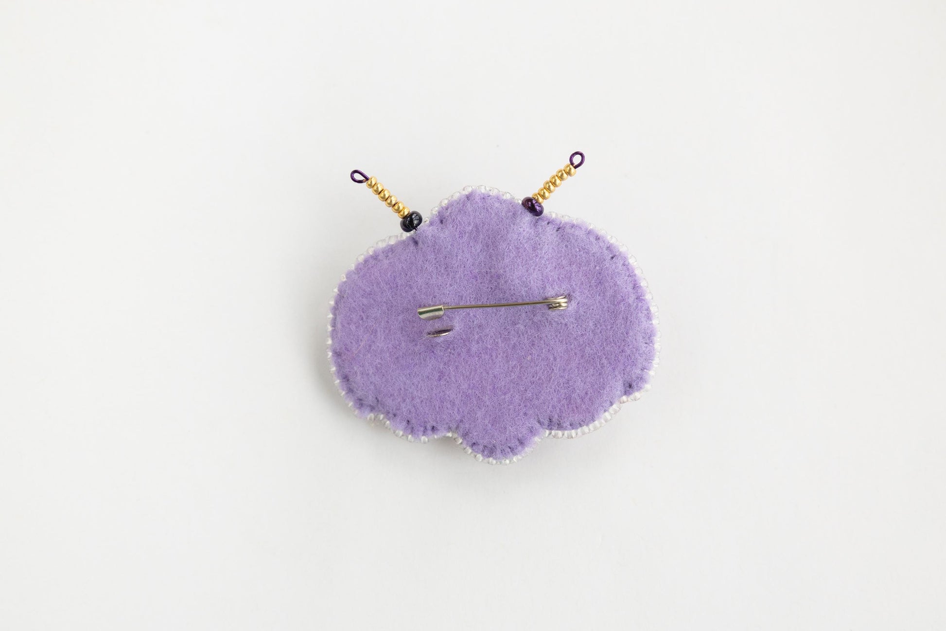 a purple pin cushion sitting on top of a white table