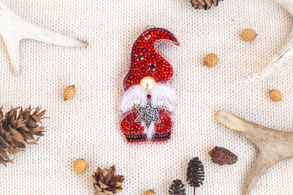 a red ornament with a white star, surrounded by various Christmas decorations such as pine cones, antlers, and acorns.