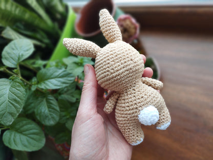 a hand holding a small crocheted stuffed animal