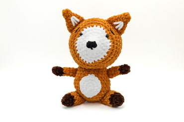 a crocheted stuffed animal is posed on a white background