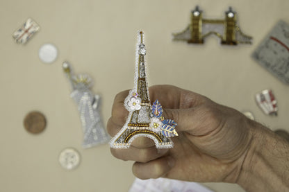 a person holding a miniature model of the eiffel tower