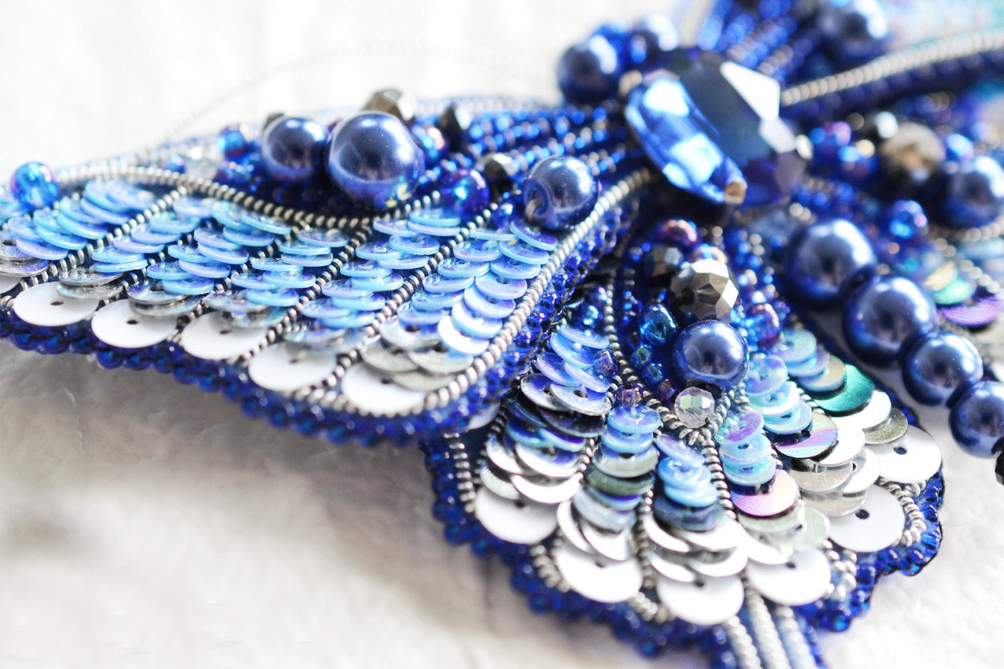 a close up of a blue and white necklace
