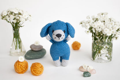 a crocheted stuffed animal next to a vase of flowers