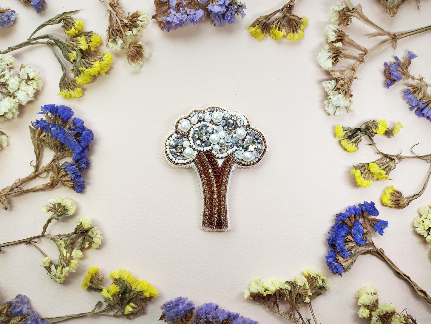 a brooch sitting on top of a table surrounded by flowers