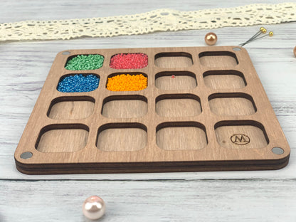 a wooden tray with beads and beads in it
