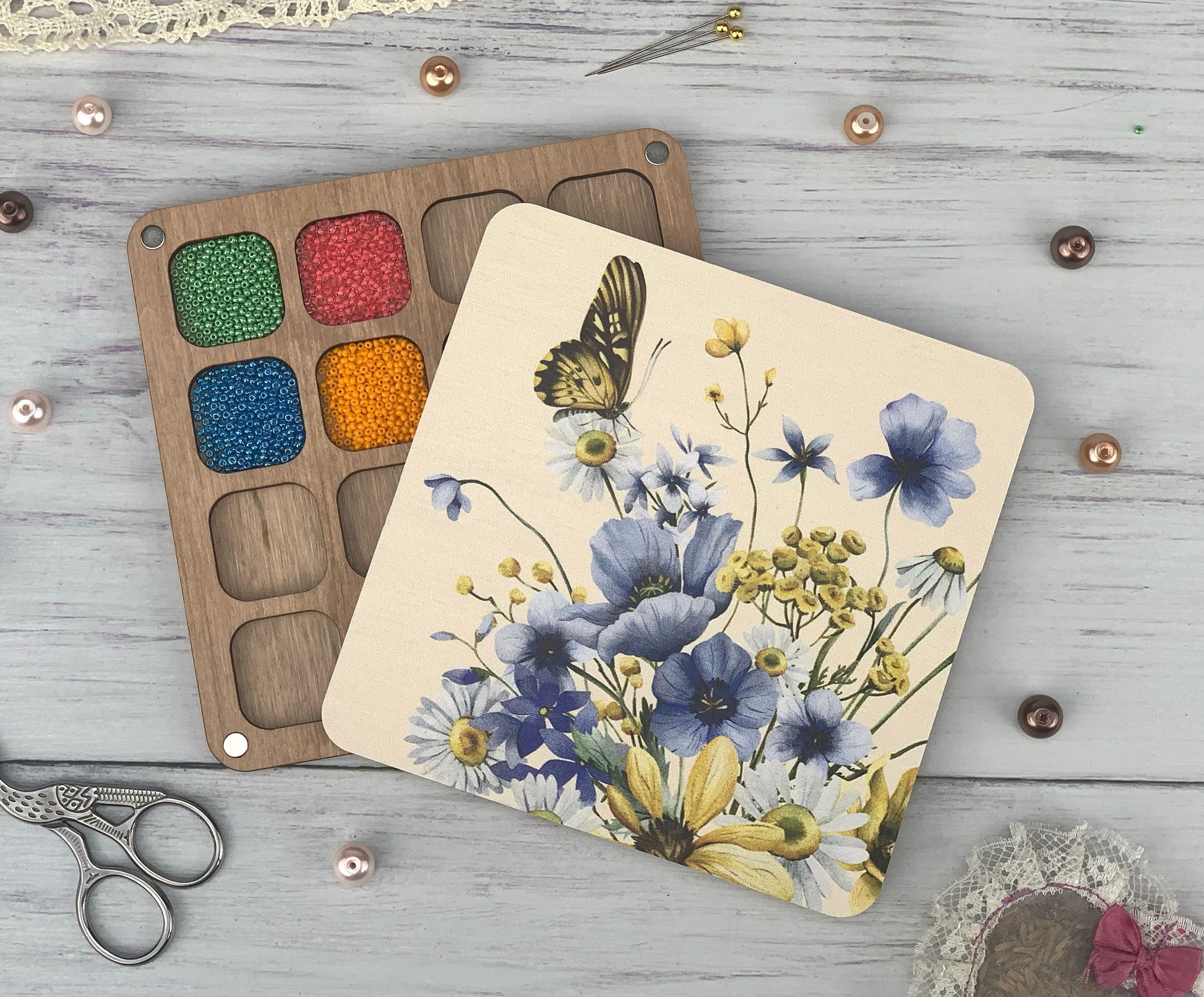 a painting of flowers and a butterfly next to a pair of scissors