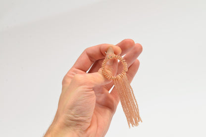 a hand holding a piece of jewelry in it&#39;s palm