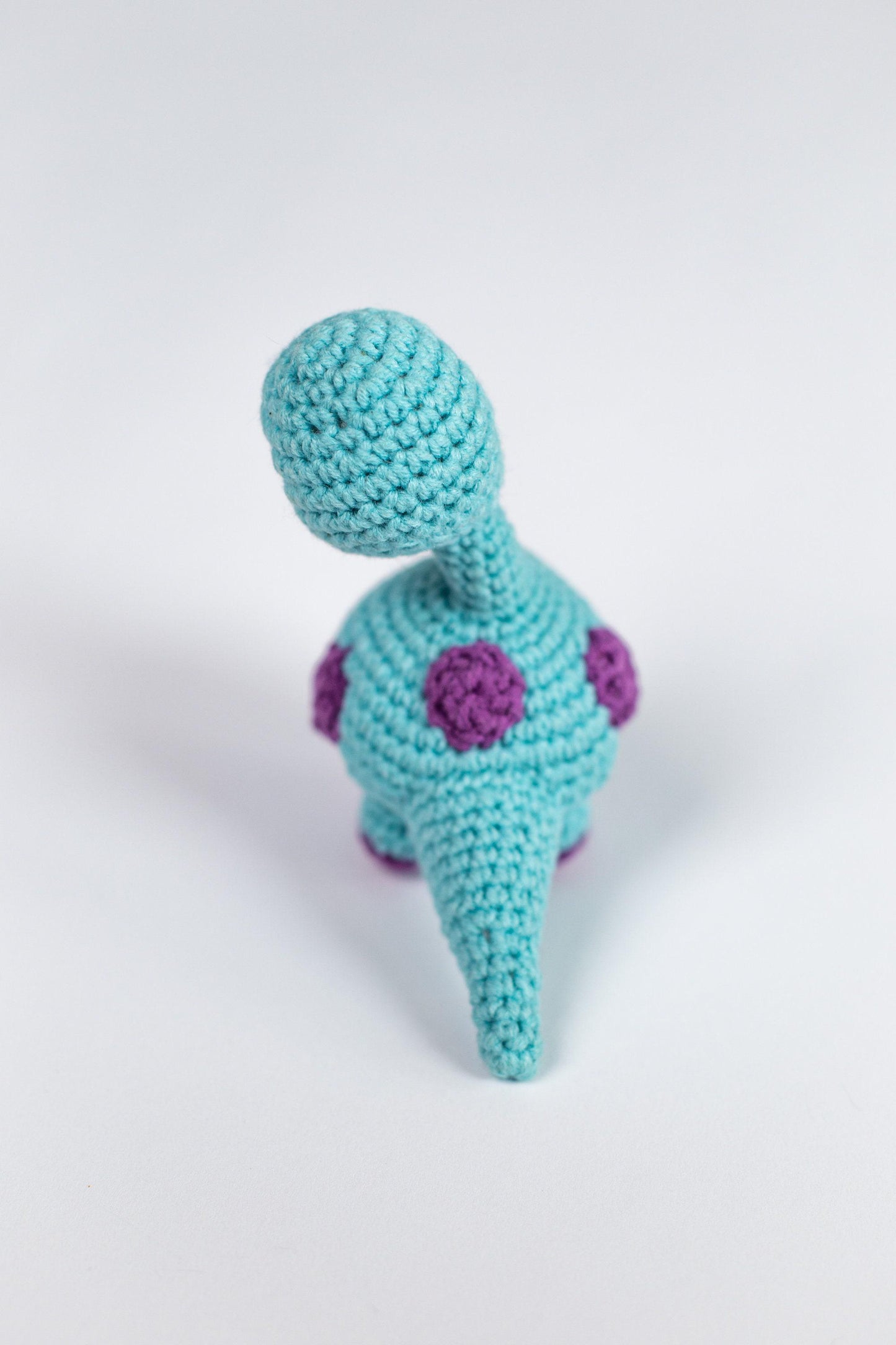 a crocheted toy is sitting on a white surface