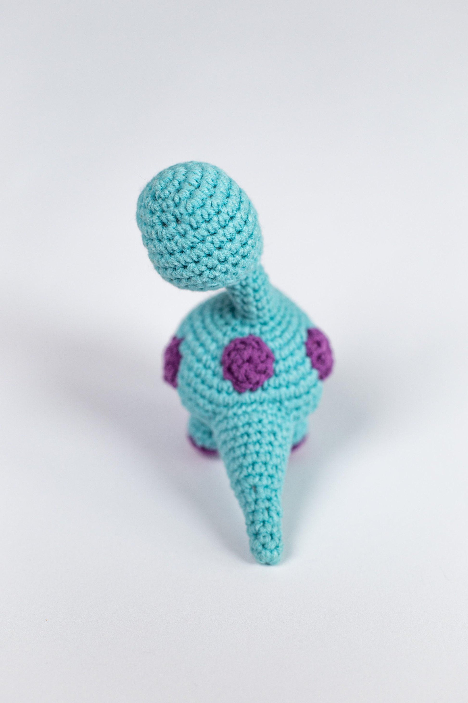 a crocheted toy is sitting on a white surface