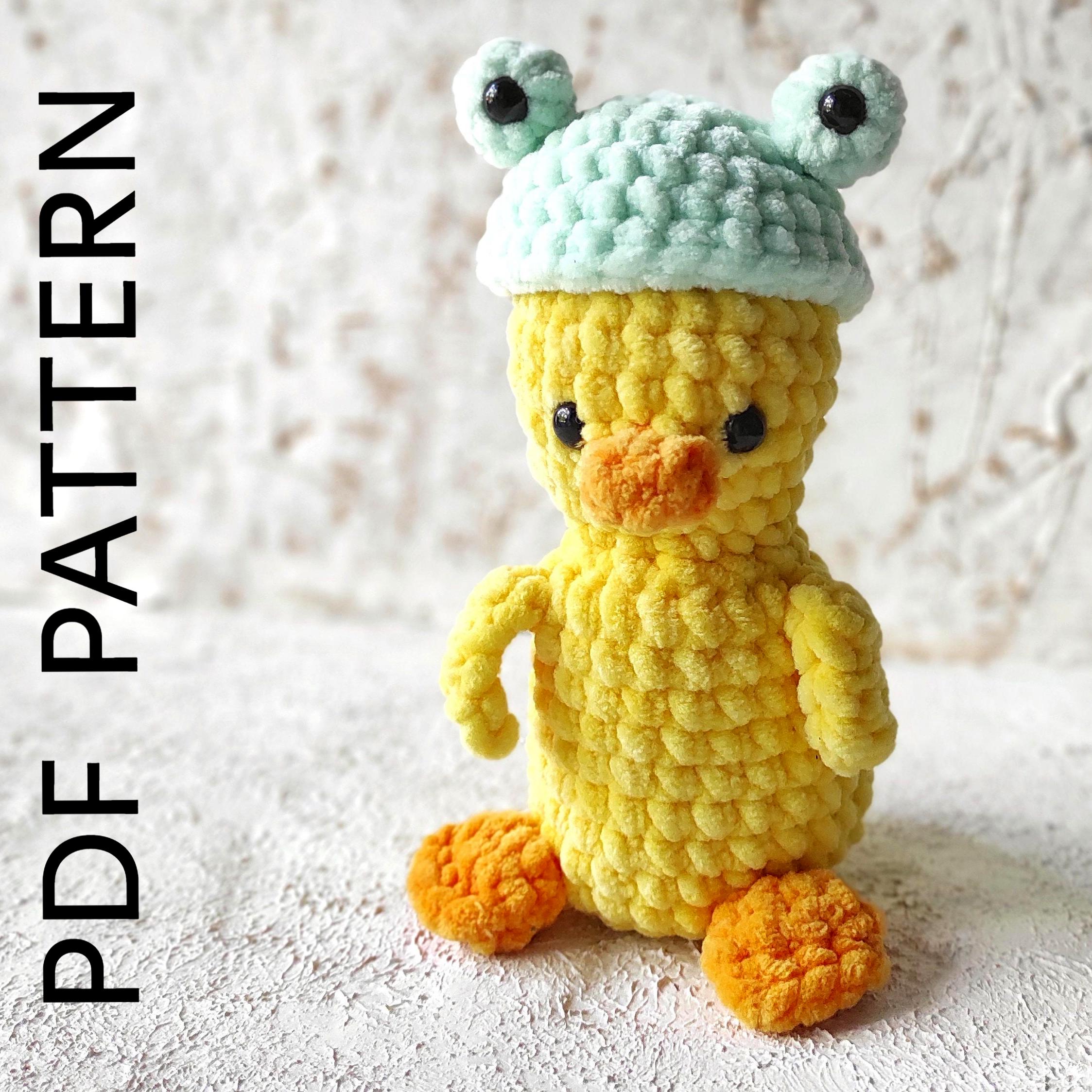 a crocheted yellow duck with a green hat
