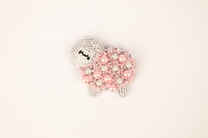 a brooch with a sheep made out of pearls