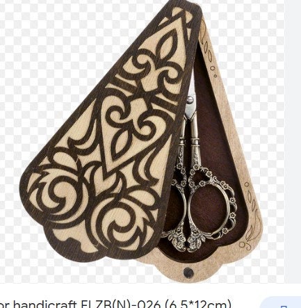 a pair of scissors sitting on top of a piece of wood