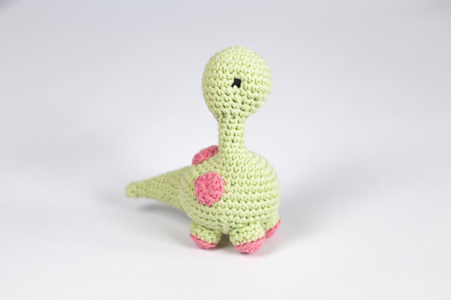 a crocheted toy of a green dinosaur
