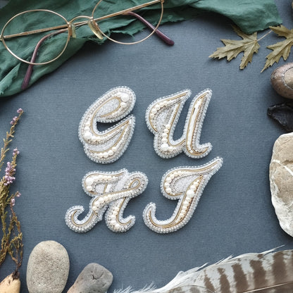 a close-up of a textured surface with various objects arranged around it, including a pair of glasses, leaves, feathers, and rocks.