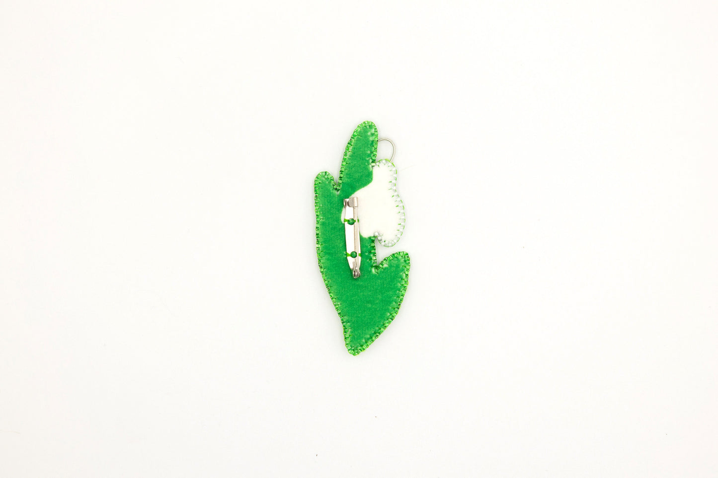 a green brooch with a cat in the middle of it