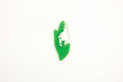 a green brooch with a cat in the middle of it
