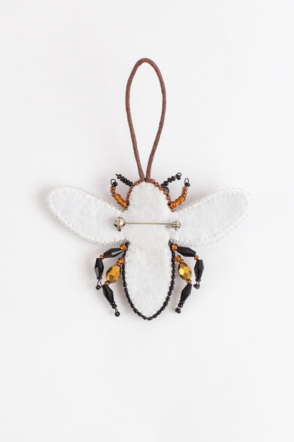 a bee ornament hanging from a cord